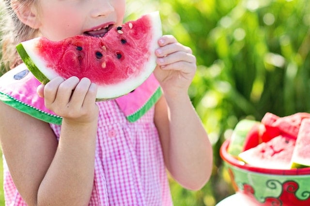 child eating a watermelon outside