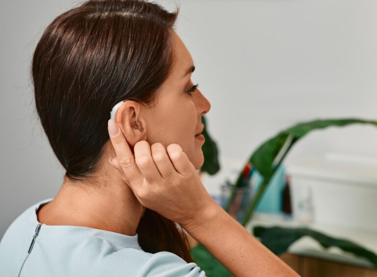 Woman touching the back of her hearing aid