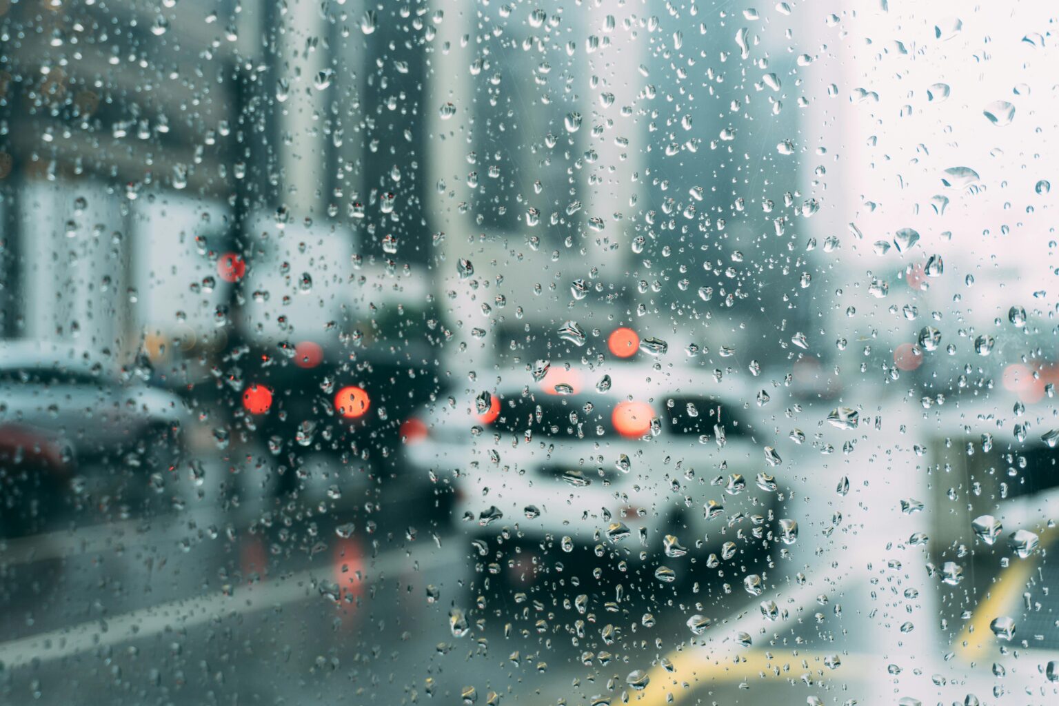 Looking out a rain-covered window at a busy street.